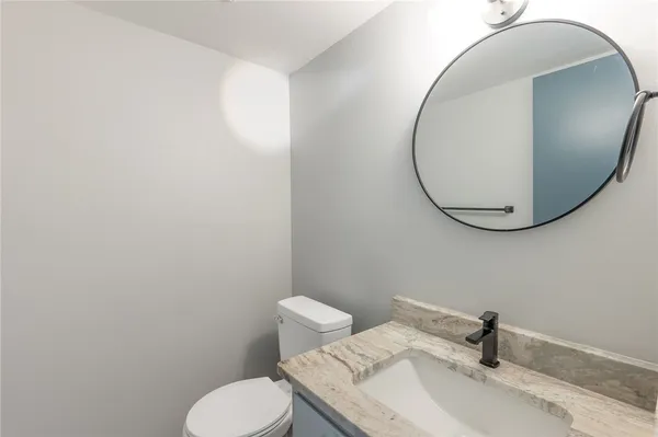 a bathroom with a sink mirror and toilet