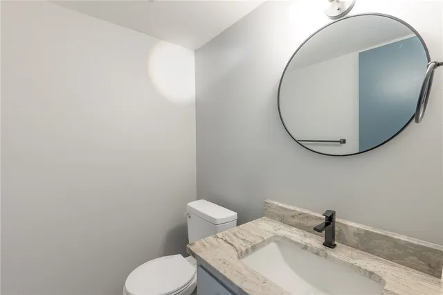 a bathroom with a sink mirror and toilet