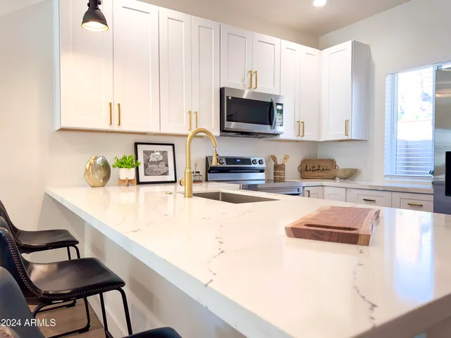a living room with stainless steel appliances kitchen island granite countertop a sink and a stove