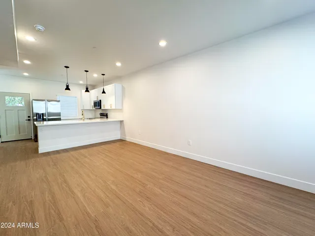 a large kitchen with kitchen island a stove a sink and a wooden floor