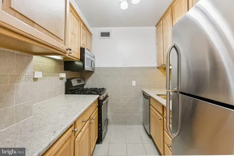 a kitchen with stainless steel appliances granite countertop a sink and a refrigerator