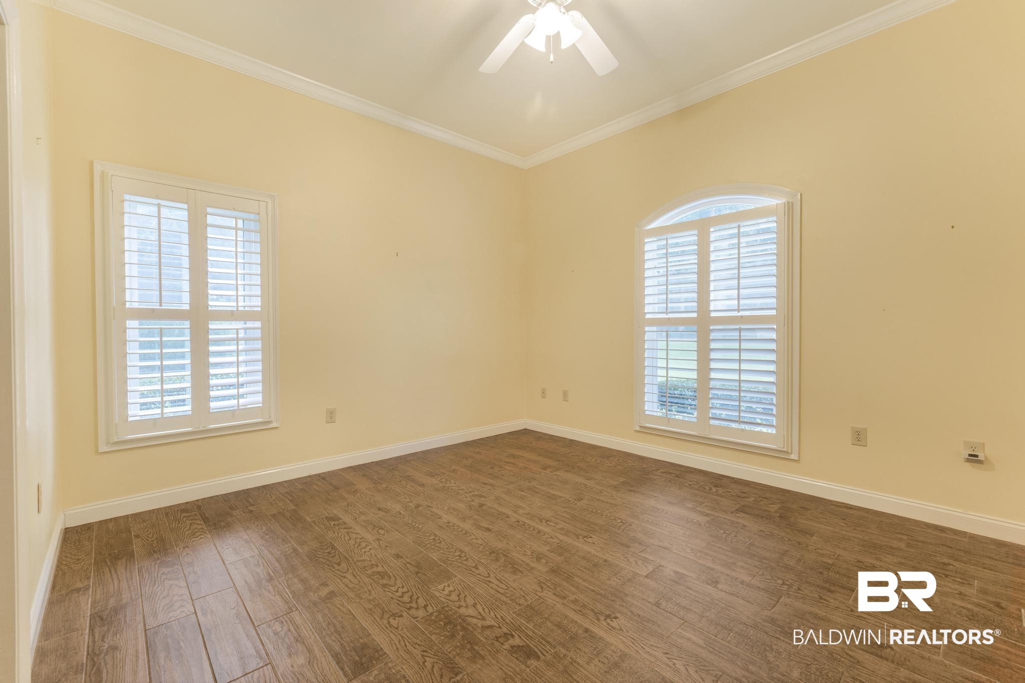 13612 Rue Royal Lane Silverhill, AL 36576 - Photo 33 of 65 Empty room featuring dark wood-style flooring, crown molding, and ceiling fan