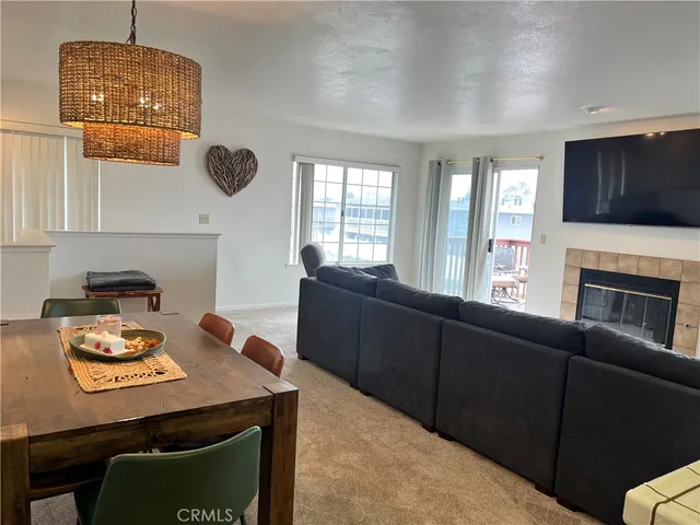 a kitchen with a refrigerator a stove top oven a sink and a dining table with wooden floor