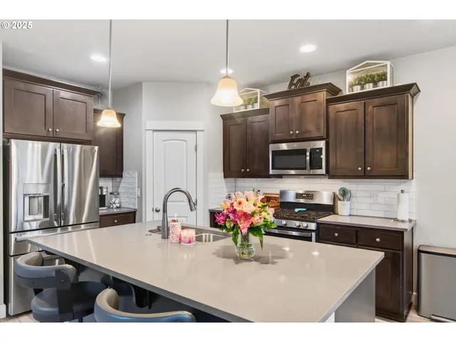 a kitchen with stainless steel appliances a sink stove and microwave