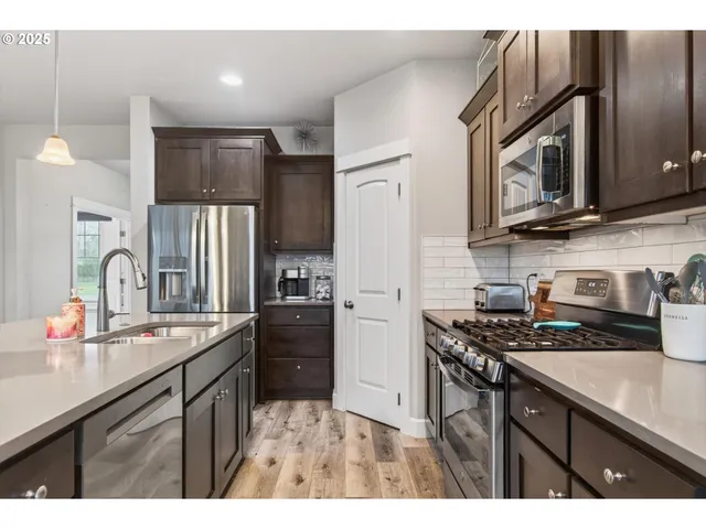 a kitchen with stainless steel appliances a sink stove and refrigerator