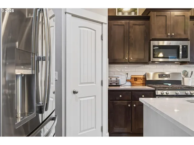 a kitchen with stainless steel appliances granite countertop a refrigerator and a stove