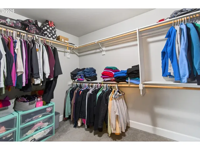 a view of walk in closet with clothes