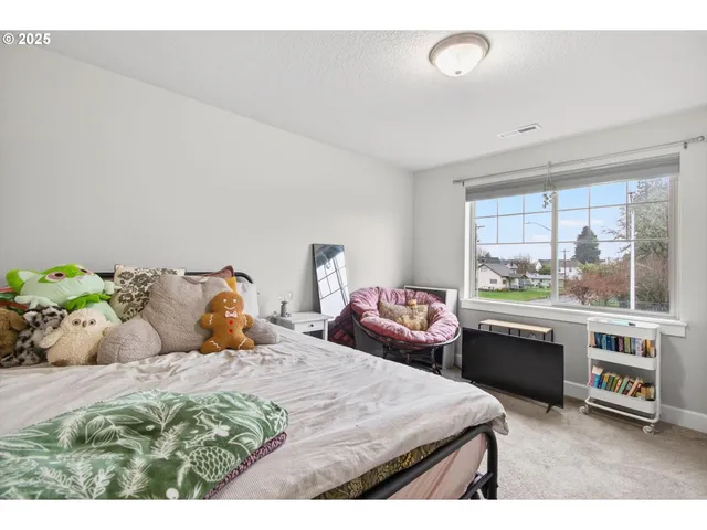 a bedroom with a bed and a large window