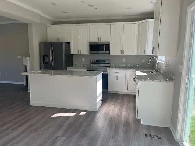 a kitchen with stainless steel appliances granite countertop a stove top oven a sink and a microwave