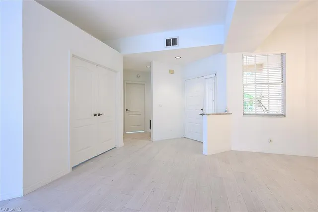 an empty room with windows and closet