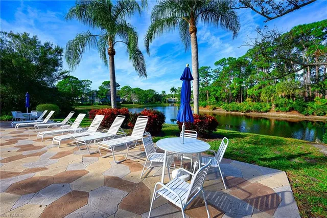 a view of a patio with a table chairs and a swimming pool