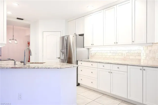 a kitchen with granite countertop white cabinets and a sink