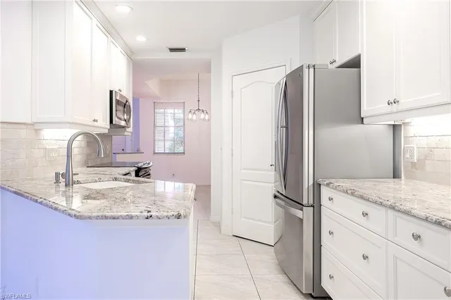 a kitchen with kitchen island a counter top space cabinets and stainless steel appliances