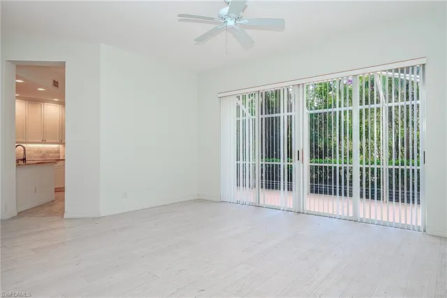 a view of a room with a large window and wooden floor