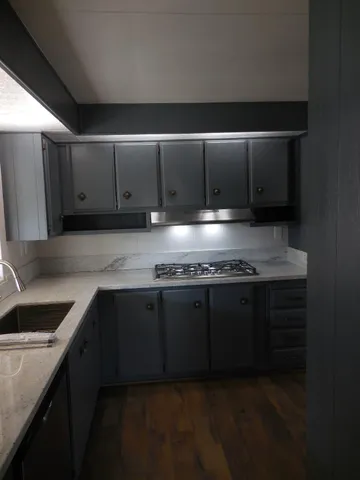 a close view of a sink a stove and kitchen counter space