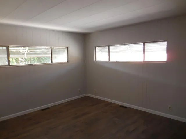 a view of a room with wooden floor and white walls