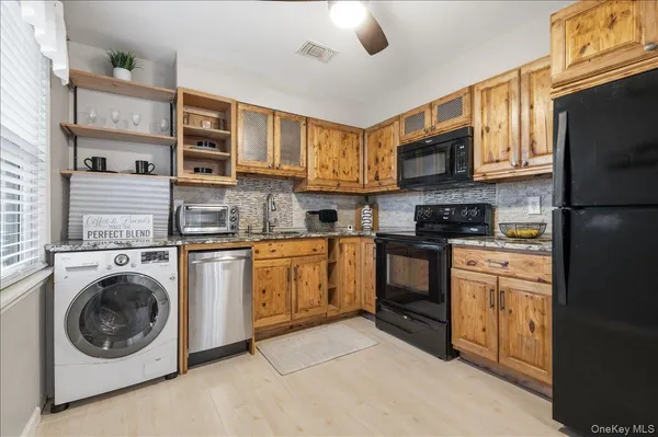a kitchen with stainless steel appliances granite countertop a stove a sink and a refrigerator
