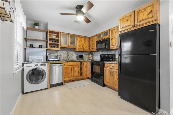 a kitchen with a refrigerator a stove top oven a washer dryer and cabinets