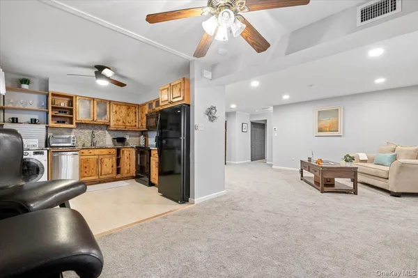 a kitchen with stainless steel appliances kitchen island granite countertop a refrigerator a stove a oven a sink with island chairs and wooden floor