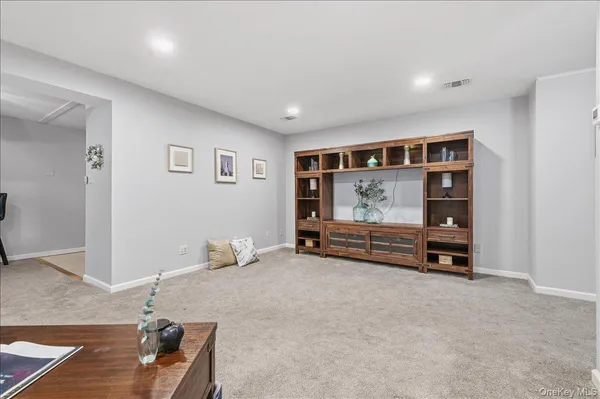 a view of an empty room with furniture and window