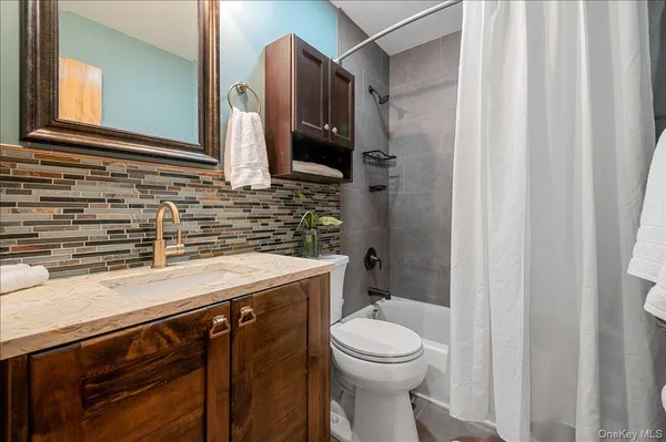 a bathroom with a granite countertop toilet sink and mirror