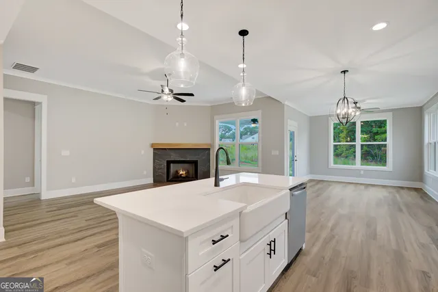 a kitchen with a sink chandelier and a fireplace