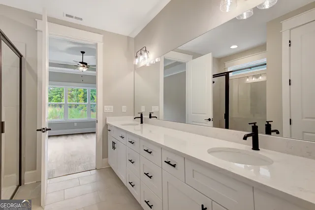 a bathroom with a double vanity sink and mirror with shower
