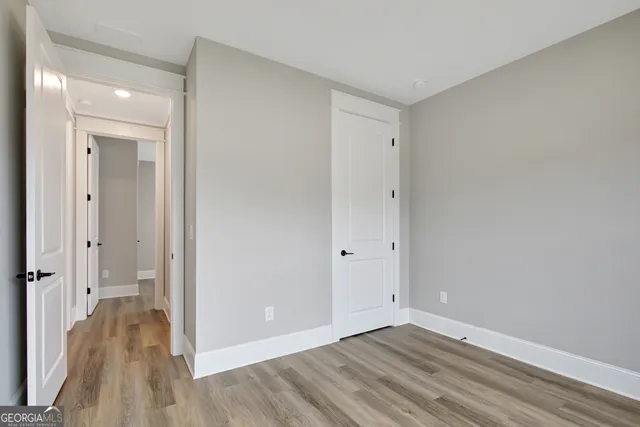 a view of a room with wooden floor and a bathroom