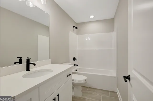 a bathroom with a granite countertop sink a toilet and shower