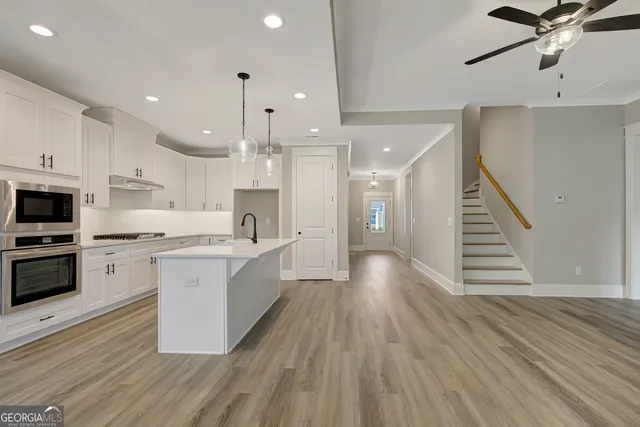 a large kitchen with stainless steel appliances kitchen island a large counter space a sink appliances and cabinets