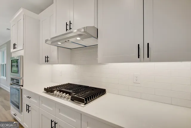 a stove top oven sitting inside of a kitchen