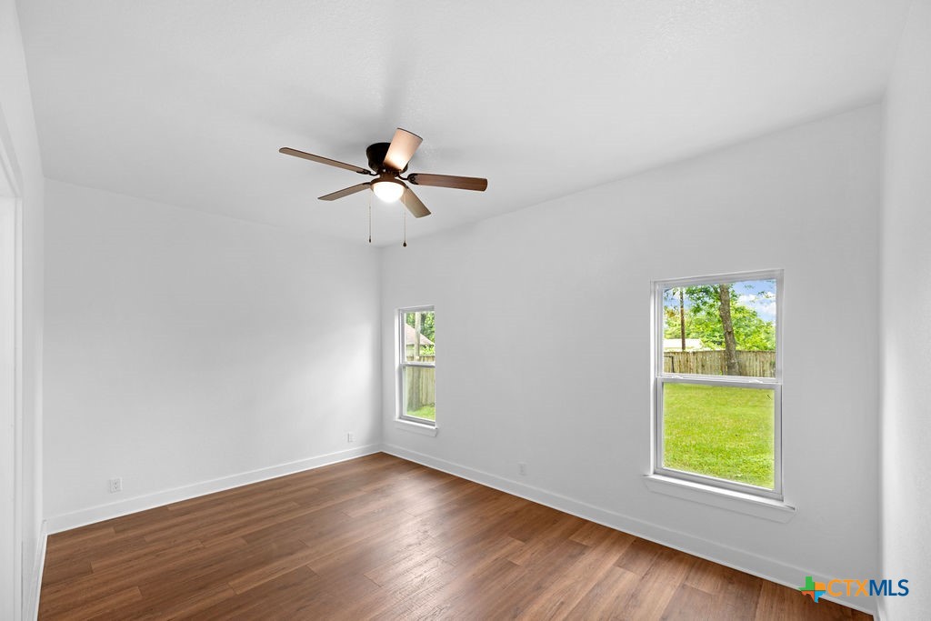 607 West 3rd Street Eddy, TX 76524 - Photo 11 of 29 an empty room with window and wooden floor
