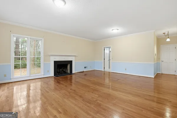 a view of an empty room with window and fireplace