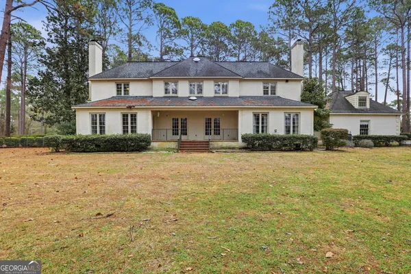 a front view of a house with yard and green space