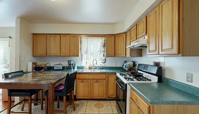 a kitchen with stainless steel appliances granite countertop a stove a sink a microwave refrigerator and cabinets