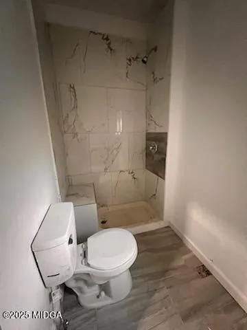 a white toilet sitting next to a bath tub