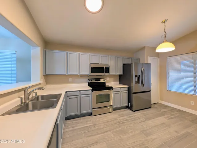 a view of a kitchen with a fridge and wooden floor