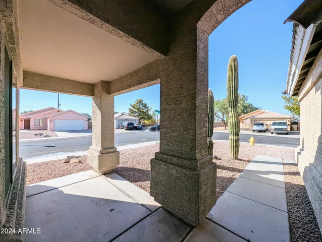a view of a hallway with wooden floor and a bathroom