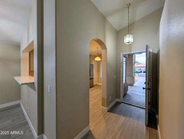 a kitchen with stainless steel appliances granite countertop a refrigerator a sink dishwasher a stove top oven a refrigerator with island and chairs