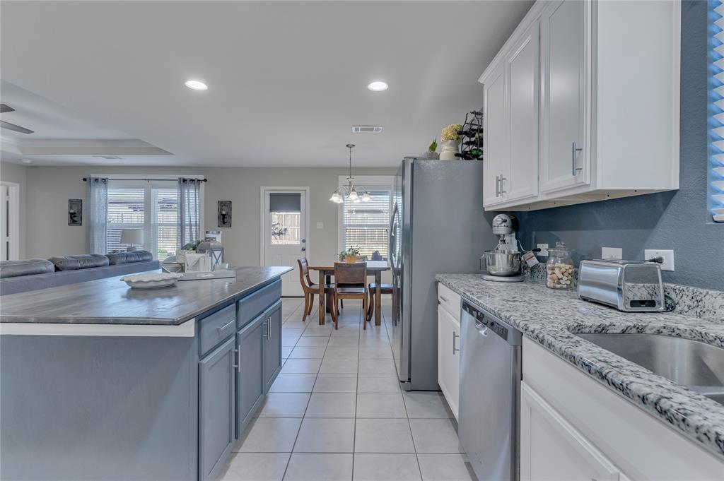 2208 Heaton Street Forney, TX 75126 - Photo 11 of 38 a kitchen with stainless steel appliances granite countertop a sink stove and cabinets