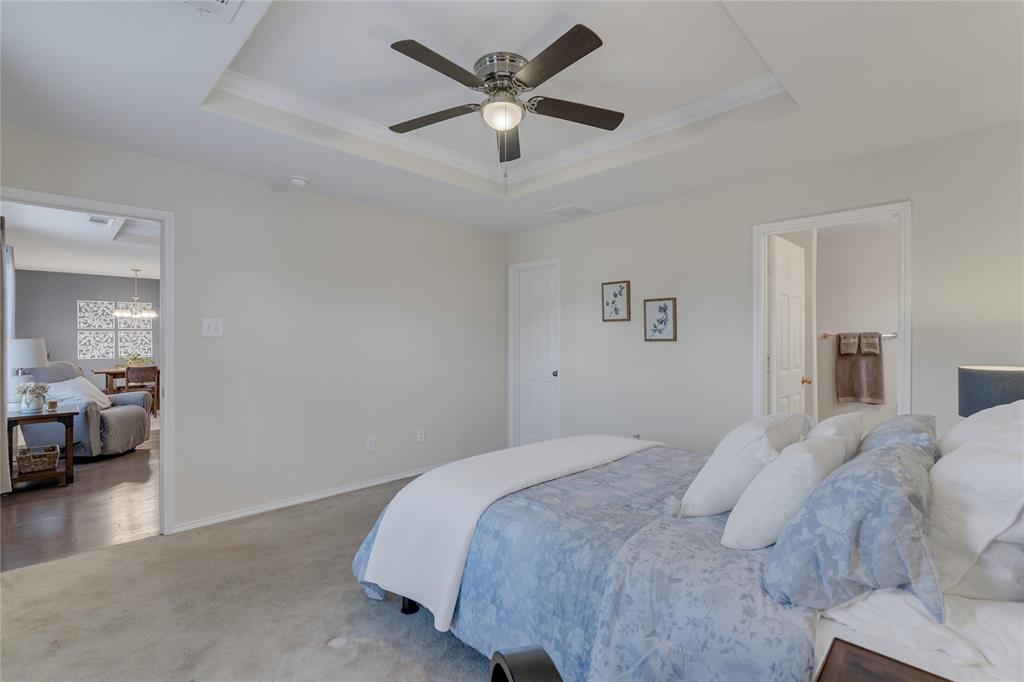 2208 Heaton Street Forney, TX 75126 - Photo 15 of 38 a bedroom with a bed and a chandelier