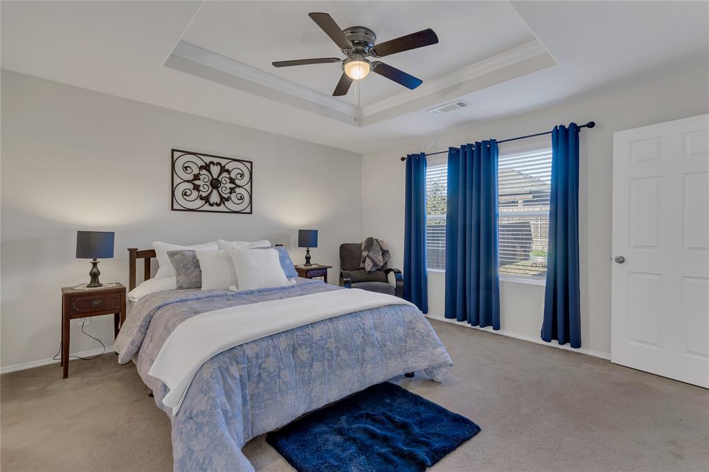 2208 Heaton Street Forney, TX 75126 - Photo 17 of 38 a spacious bedroom with a bed and a chandelier