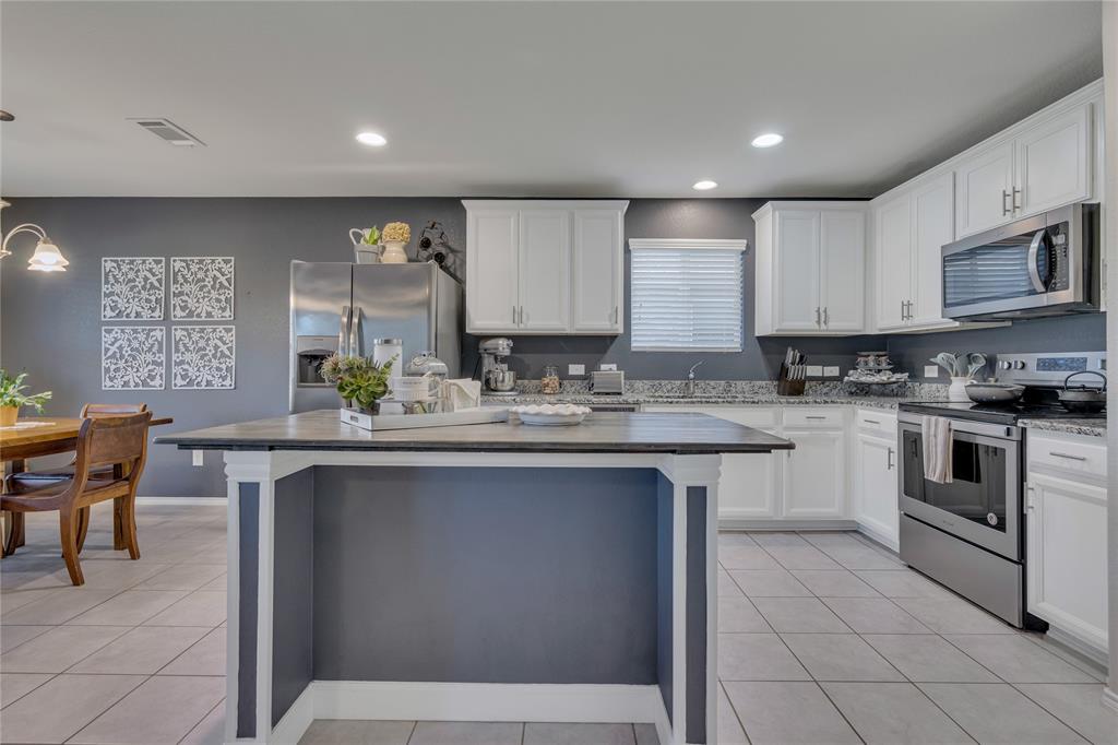 2208 Heaton Street Forney, TX 75126 - Photo 9 of 38 a kitchen with stainless steel appliances granite countertop a stove a sink and a refrigerator