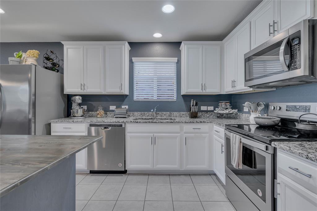 2208 Heaton Street Forney, TX 75126 - Photo 10 of 38 a kitchen with stainless steel appliances granite countertop a sink stove and refrigerator