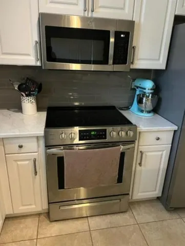 a stove top oven sitting inside of a kitchen