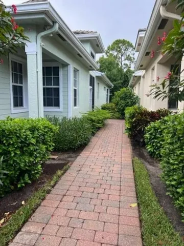 a pathway of a house with potted plants