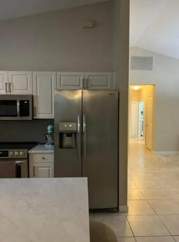 a kitchen with stainless steel appliances granite countertop a refrigerator and a stove