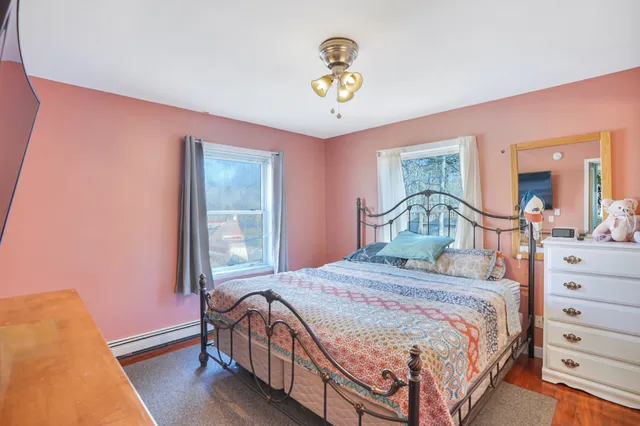 a bedroom with a bed a chandelier and a dresser