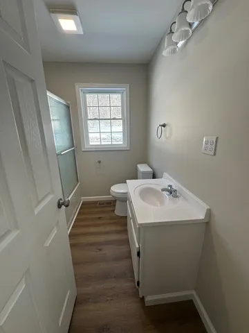 a bathroom with a sink toilet and a window