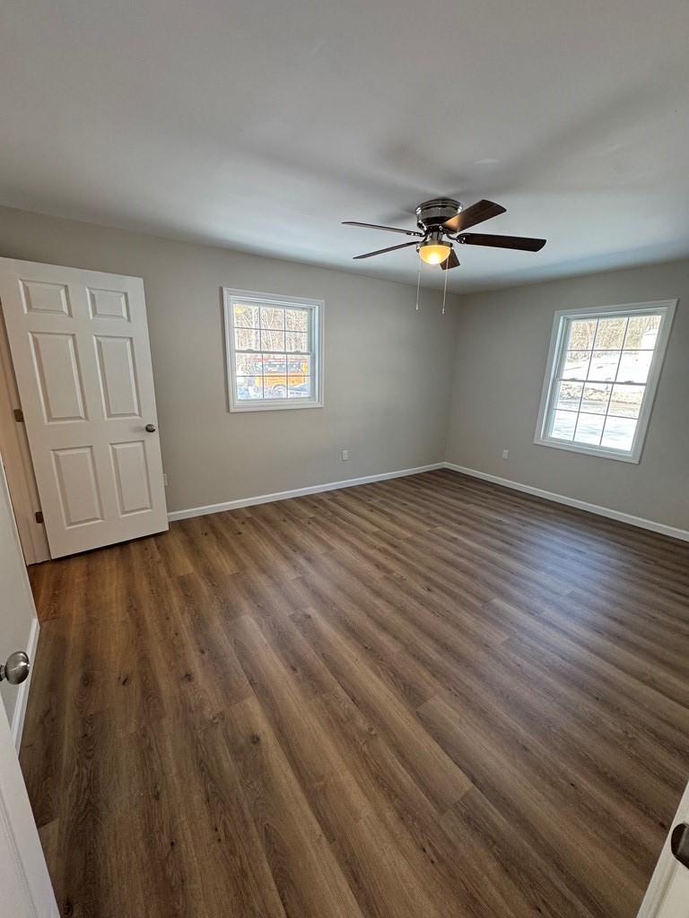 1106 East Railroad Street Waverly, TN 37185 - Photo 19 of 21 an empty room with wooden floor chandelier fan and windows
